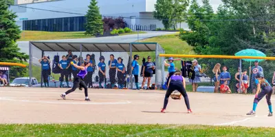 Group of women on baseball pitch playing baseball.