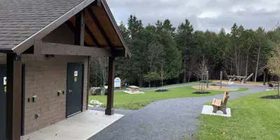 Path with washroom facility and play structure in background.