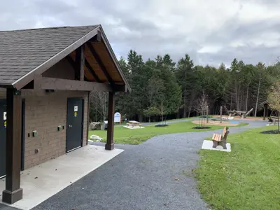 Path with washroom facility and play structure in background.