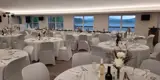 Event area decorated for wedding with head table and rounds of tables.